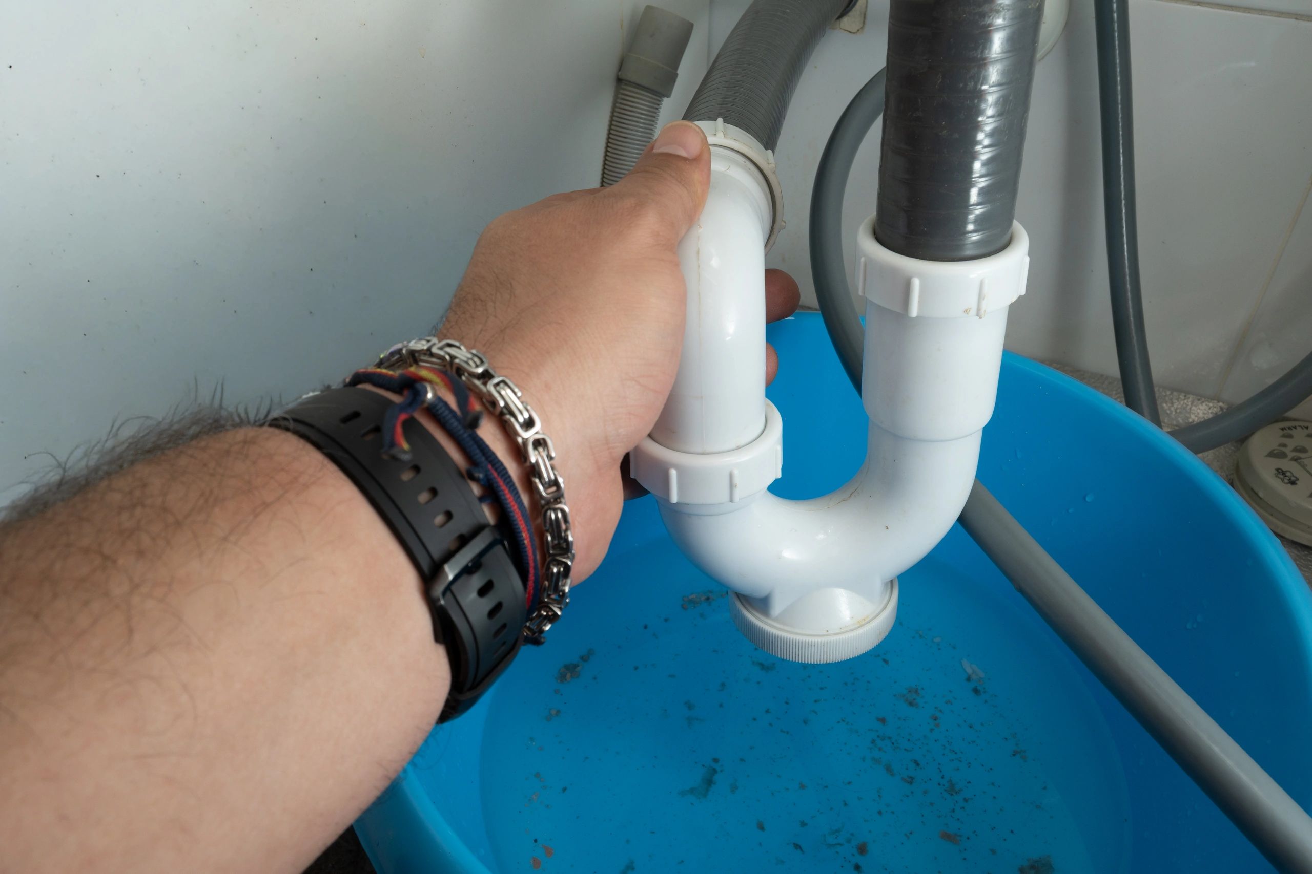 Plumber repairing sink drain pipe